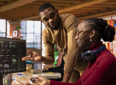Team of technicians brainstorming in startup office, coding advanced AI Team of technicians brainstorming in startup office, coding advanced AI algorithm and machine learning models. African american colleagues talk in artificial intelligence Silicon Valley workplace